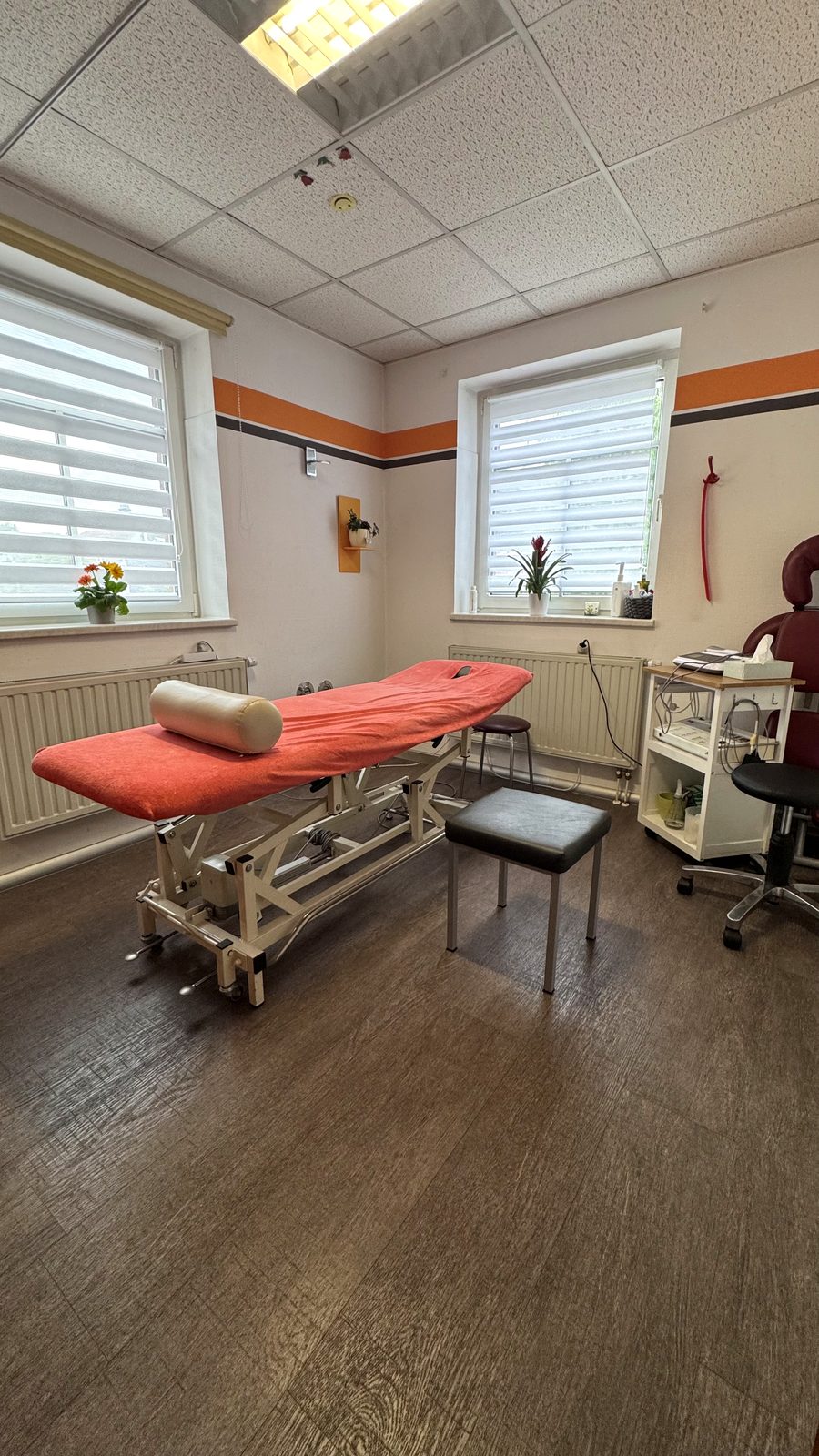Heller Behandlungsraum der Physiotherapie Senftleben mit Behandlungsliege und großen Fenstern